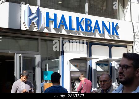 Istanbul, Turkey - October-10.2019: Halkbank's branch on Istiklal Street. People withdraw money at the ATM. They enter and leave the bank. It is a Stock Photo