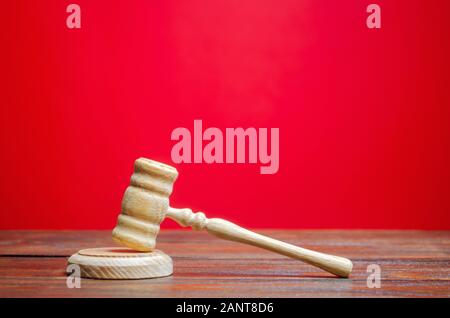 Judge's hammer on a red background. The judicial system. Norms, rules and laws. Conflict resolution in court. Court case, settling disputes. Protectio