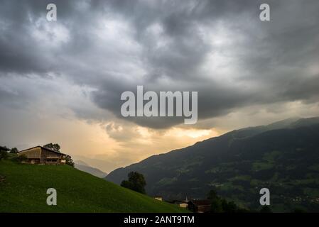 Thunderstorm with ufo shaped lenticular cloud over a valley in the Alps Stock Photo