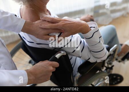 Close up caregiver and disabled older woman holding hands Stock Photo