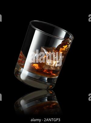 falling glass of whiskey with ice cubes on black background Stock Photo