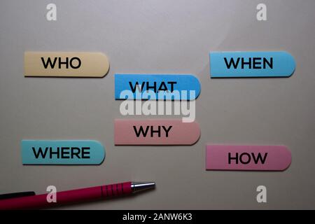 Who, What, When, Where, Why, How write on a sticky note isolated on office desk. Stock Photo