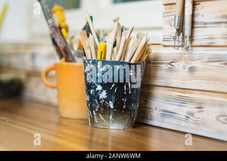 Plates and tools on pottery studio table, shallow debt of field, small art business concept Stock Photo