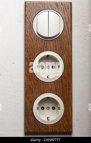 Three electric white outlet socket on gray wall EU standard Stock Photo