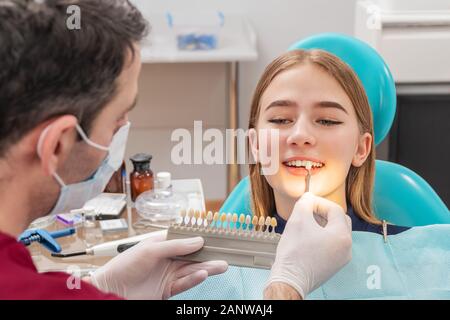 dentist determines the color of the patient teeth using probes Stock Photo