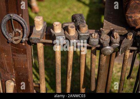 Hammers of different sizes. Vintage blacksmith tools. Forge in the open air during the living history festival Stock Photo