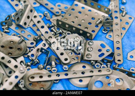 The iron parts of the designer are scattered on the table. Metal constructor. Human brain development Stock Photo