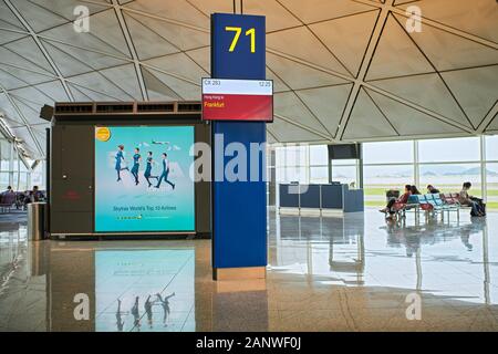 Hong Kong: View of modern looking departure area inside Hong Kong International Airport with passengers waiting for their flights Stock Photo