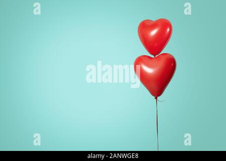 Two heart shaped red air baloon front of a font. Valentined day and romance concept Stock Photo