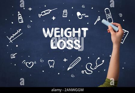 Hand drawing WEIGHT LOSS inscription with white chalk on blackboard, medical concept Stock Photo