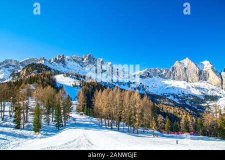Ski slope in Dolomites mountain range Val di Fassa area, Catinaccio / Rosengarten ski area near Vigo di Fassa, Trentino, Italy Stock Photo