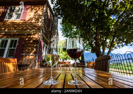 https://l450v.alamy.com/450v/2anwgxh/two-different-glasses-sizes-and-wines-red-and-white-wine-on-wooden-table-close-up-selective-focus-farmhouse-backyard-patio-furniture-okanagan-valley-2anwgxh.jpg