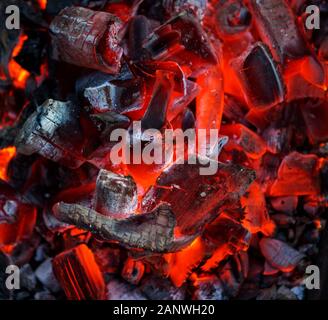 Burning coal. Glowing embers smoldering. Fire place with glowing coal. Live coal burning. Background. Close-Up. Stock Photo