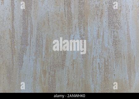 Light beige peach with mother-of-pearl glitter plaster background with vertical stripes of smears. Stock Photo
