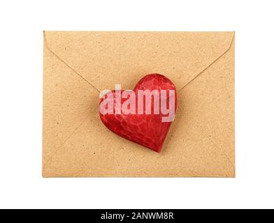 Close up one red painted natural wooden carved heart over brown paper envelope isolated on white background Stock Photo