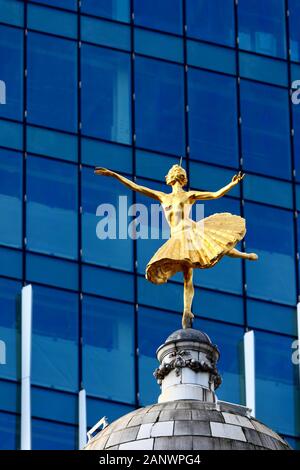 Statue of Russian ballerina Anna Pavlova on top of the dome of Victoria Palace Theatre and glass fronted building, Victoria, London, UK Stock Photo