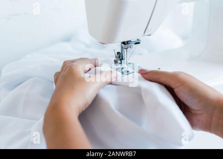 Adjusting fabric under needle of sewing machine Stock Photo