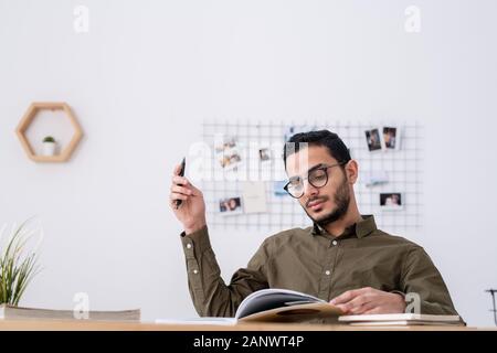 Young male student with open book looking through study materials Stock Photo