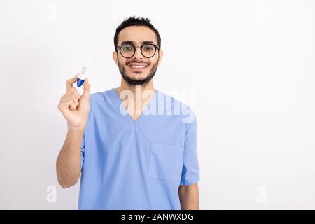 Successful young male practitioner in blue uniform holding thermometer Stock Photo