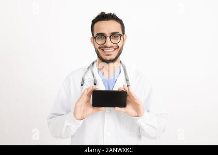 Cheerful young doctor with toothy smile photographing you on smartphone Stock Photo