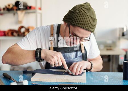 Using calipers in leatherworking Stock Photo