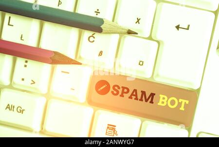 Handwriting text writing Spam Bot. Conceptual photo autonomous program on the Internet that sends spam to users White pc keyboard with empty note pape Stock Photo