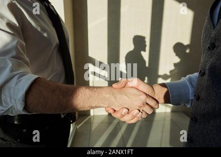 Handshake of two young elegant business partners after negotiating Stock Photo