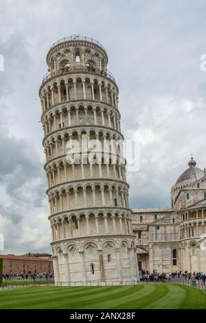 The Leaning Tower of Pisa is a bell tower surrounded by visitors and tourists near the cathedral in the Italian city of Pisa Stock Photo