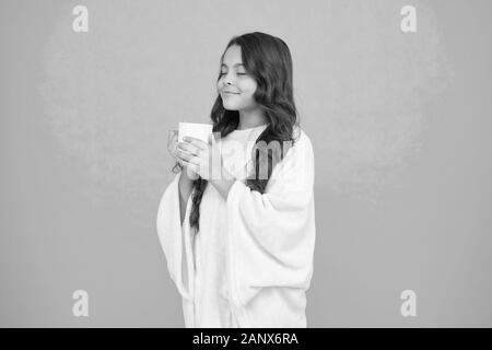 Relaxation before sleep. Drinking milk just before heading to bed. Bedtime Beverages. Evening routine. Health Benefits of Drinking Milk Before Bed. Little child hold mug. Girl in pajamas drinking tea. Stock Photo