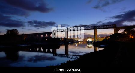 Skyline of Drogheda with night lights through the Boyne Viaduct seen from river banks Stock Photo