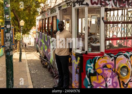 Lisbon Portugal - July 22, 2019: A tram driver waits for passengers at the graffiti-covered Elevador da Glória funicular in Bairro Alto, Lisbon. Stock Photo