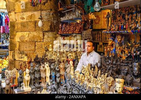 Souvenir stall owner sits amongst a treasure trove of souvenirs in the Khan el-Khalili market in the Islamic District of Cairo Stock Photo