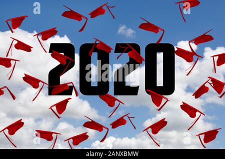 airborne red 2020 graduation hats with tassels in summer blue sky Stock Photo