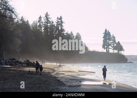 Vancouver, Canada - Jan 1,2020: A View of Third Beach in Stanley Park in Vancouver during the sunny winter day with people walking in the background Stock Photo
