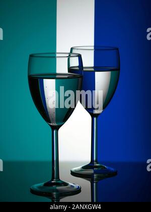 Wine glasses on striped blue and mint background. Trendy color 2020 Stock Photo