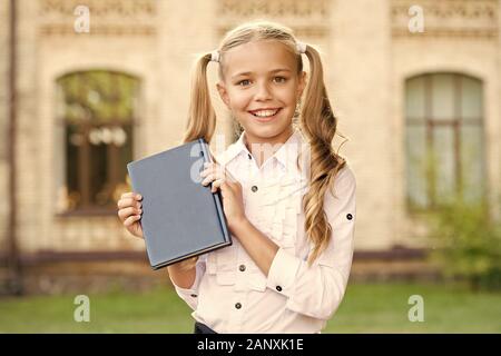 Ready for lessons. Secondary school student. Cute smiling small child hold book. Adorable little girl school student. Study language. School education concept. Cute little bookworm. Knowledge day. Stock Photo