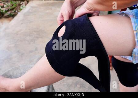 Close up of knee support brace on leg of a traveler woman, Wearing protective equipment to maintain important parts of the body before exercise Stock Photo
