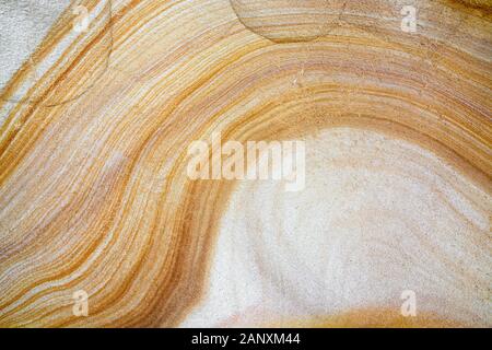 Close-up of natural sandstone texture with yellow and white layered wave pattern Stock Photo