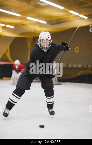 Full length portrait of female hockey player leading pluck during practice on ice, copy space Stock Photo