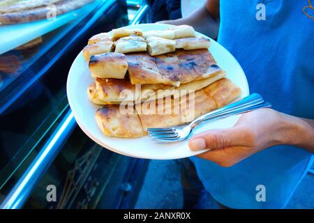 Prairie (meadow, moor) pide with cheese, mince and potatoes. Black Sea region,' Kastamonu ' province of Turkish pide. the waitress is serving Stock Photo