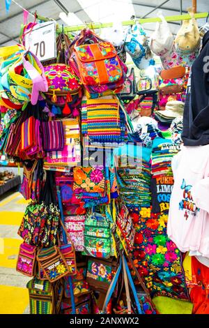 Puerto Limon, Costa Rica - December 8, 2019: Ethnic souvenirs, baseball caps, bags with various pattern hanging in street market Stock Photo