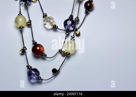 Close up view of a colorful glass beaded costume jewelry necklace on white neutral background with copy space Stock Photo