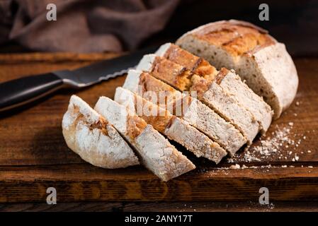 Sourdough white bread sliced on wooden cutting board, closeup view. Wheat bread Stock Photo