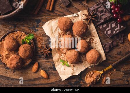 Homemade chocolate truffles with cocoa powder, spices and nuts. Table top view. Messy preparation of chocolate truffles Stock Photo