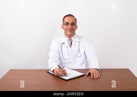 Mature Persian man doctor working behind desk Stock Photo