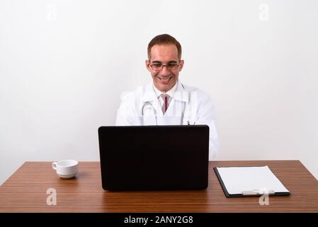 Mature Persian man doctor working behind desk Stock Photo