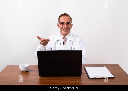 Mature Persian man doctor working behind desk Stock Photo