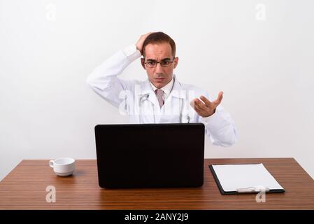 Mature Persian man doctor working behind desk Stock Photo