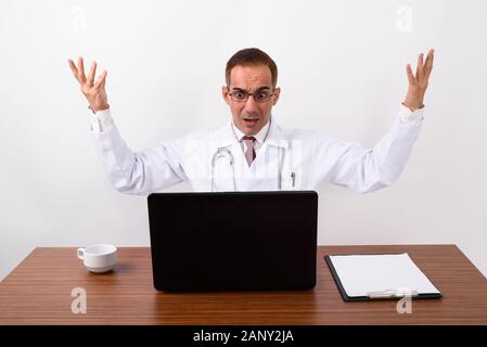 Mature Persian man doctor working behind desk Stock Photo