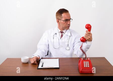 Mature Persian man doctor working behind desk Stock Photo